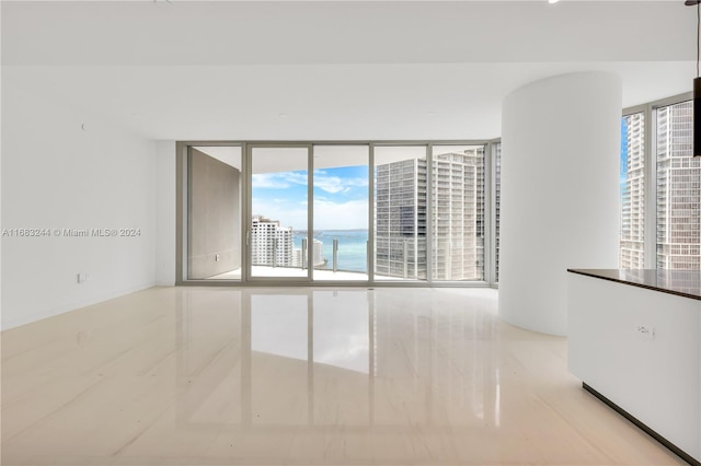 empty room featuring a water view and expansive windows