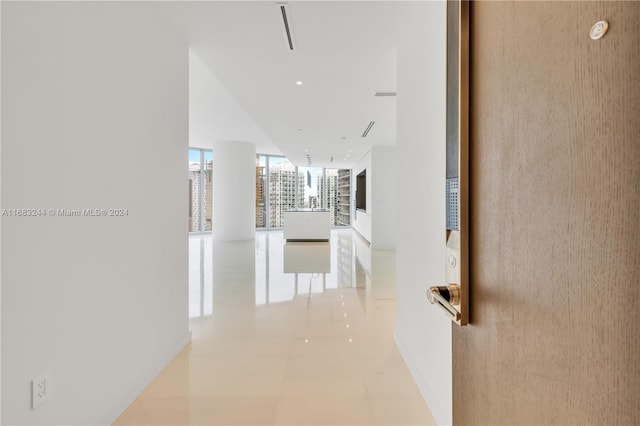 hall featuring expansive windows and light tile patterned floors