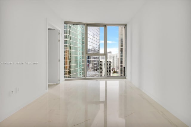 unfurnished room featuring a wall of windows