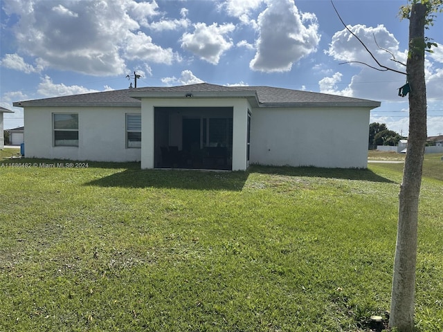 rear view of house featuring a yard