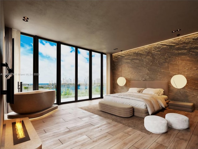 bedroom with multiple windows, light hardwood / wood-style flooring, and floor to ceiling windows