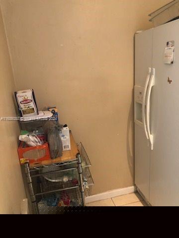 kitchen featuring white fridge with ice dispenser and light tile patterned floors