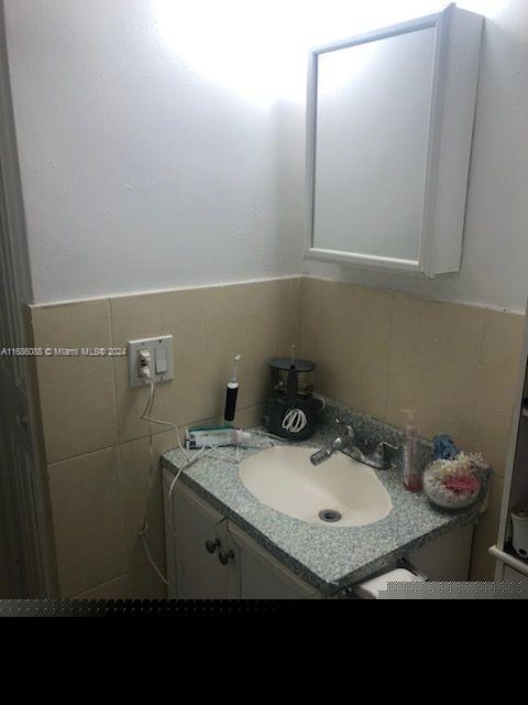 bathroom featuring tile walls and vanity