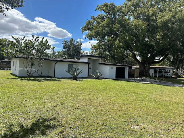 2128 Sycamore Dr, Winter Park, FL 32789 - back of property with an attached garage, stucco siding, a yard, and concrete driveway
