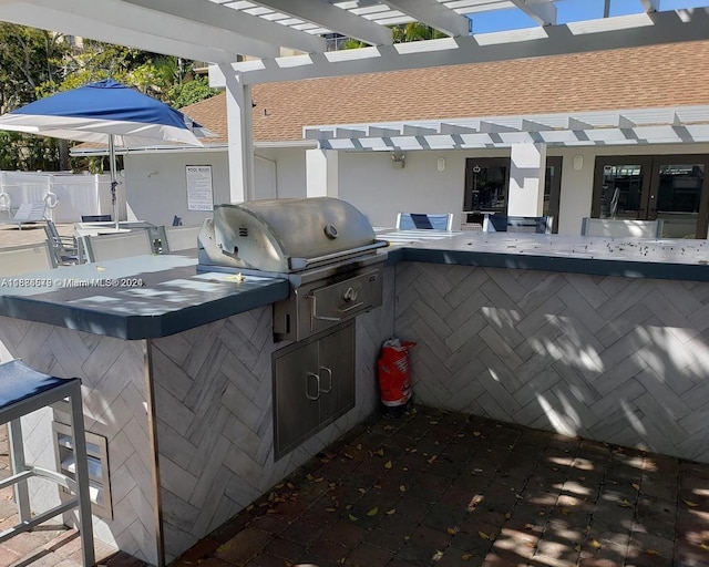 view of patio with exterior kitchen, area for grilling, and a pergola