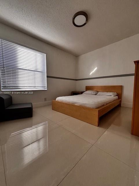 unfurnished bedroom featuring light tile patterned floors and a textured ceiling