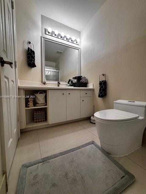 bathroom featuring tile patterned flooring, vanity, and toilet