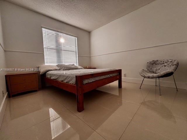 bedroom featuring light tile patterned floors and a textured ceiling