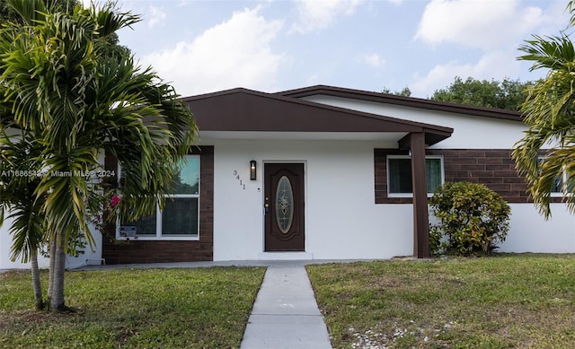 single story home with a front lawn