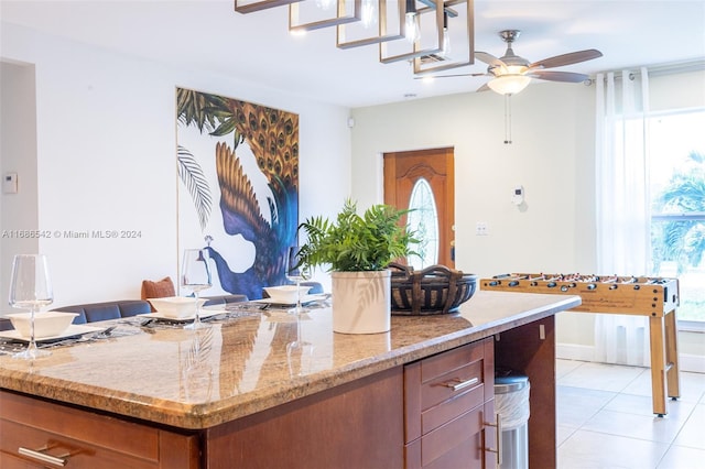 kitchen featuring light stone countertops, light tile patterned flooring, and ceiling fan