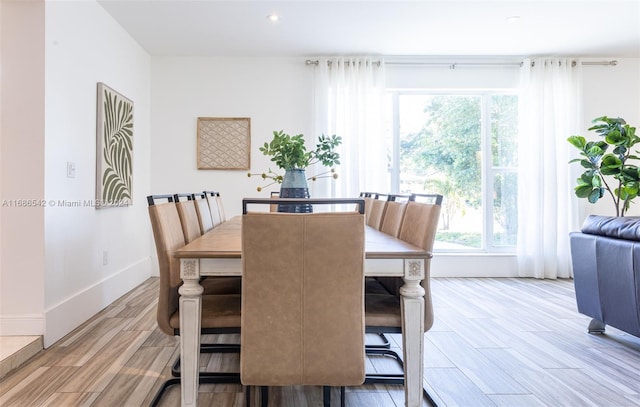 dining space with light hardwood / wood-style flooring and plenty of natural light