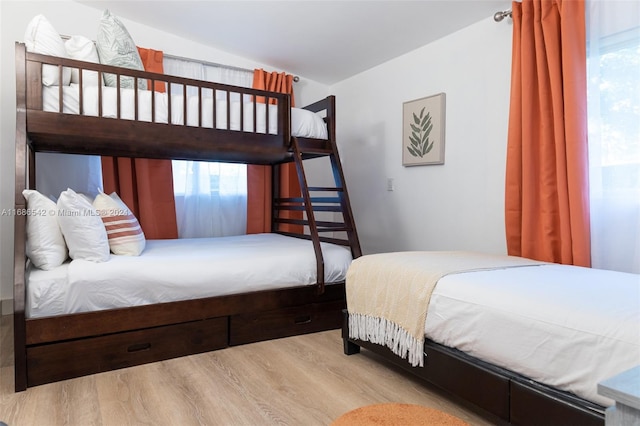 bedroom featuring lofted ceiling and light wood-type flooring