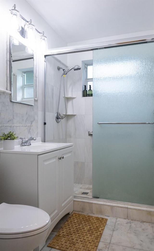 bathroom featuring vanity, an enclosed shower, and toilet