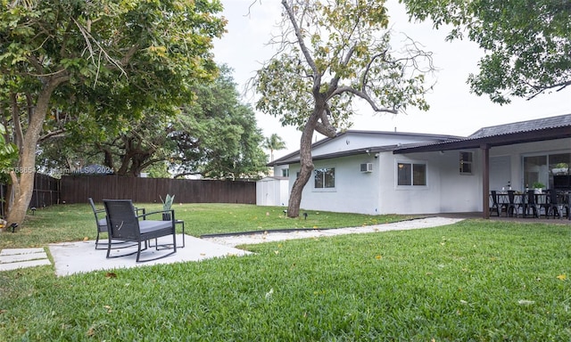 view of yard featuring a wall unit AC, a shed, and a patio area