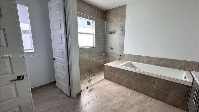 bathroom with a healthy amount of sunlight, tile patterned floors, and plus walk in shower