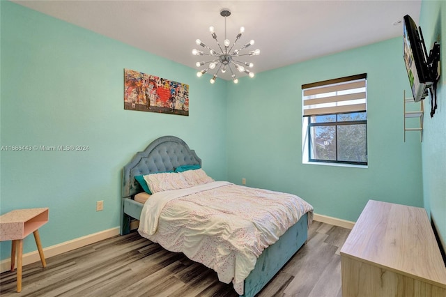 bedroom with hardwood / wood-style floors and a chandelier