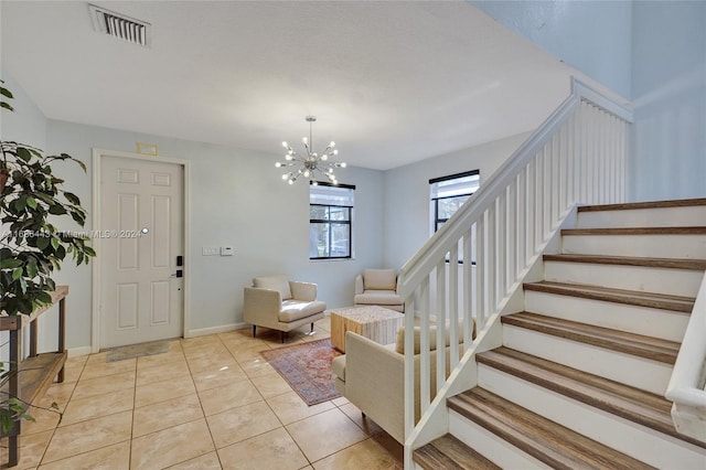 tiled foyer entrance with a notable chandelier