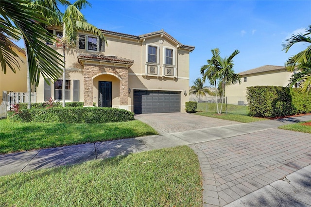 mediterranean / spanish-style house featuring a front yard and a garage