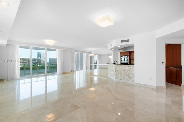 empty room featuring floor to ceiling windows and sink