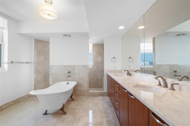 bathroom featuring vanity, shower with separate bathtub, and tile walls