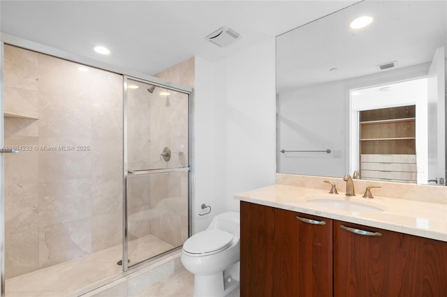 bathroom featuring vanity, tile patterned floors, a shower with door, and toilet