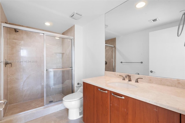 bathroom with vanity, tile patterned flooring, a shower with shower door, and toilet