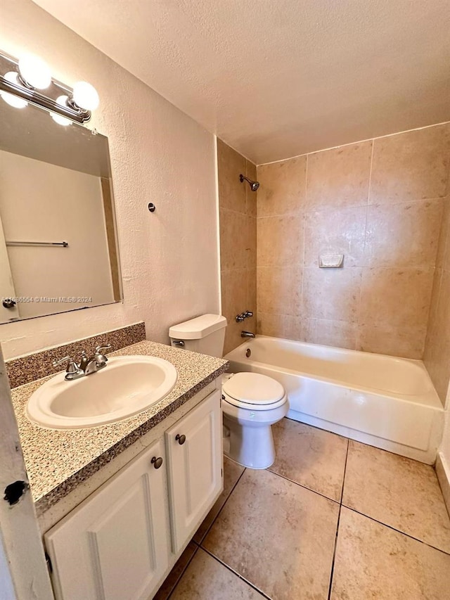 full bathroom with vanity, toilet, a textured ceiling, and tiled shower / bath