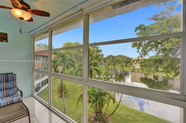 sunroom featuring ceiling fan, a water view, and plenty of natural light