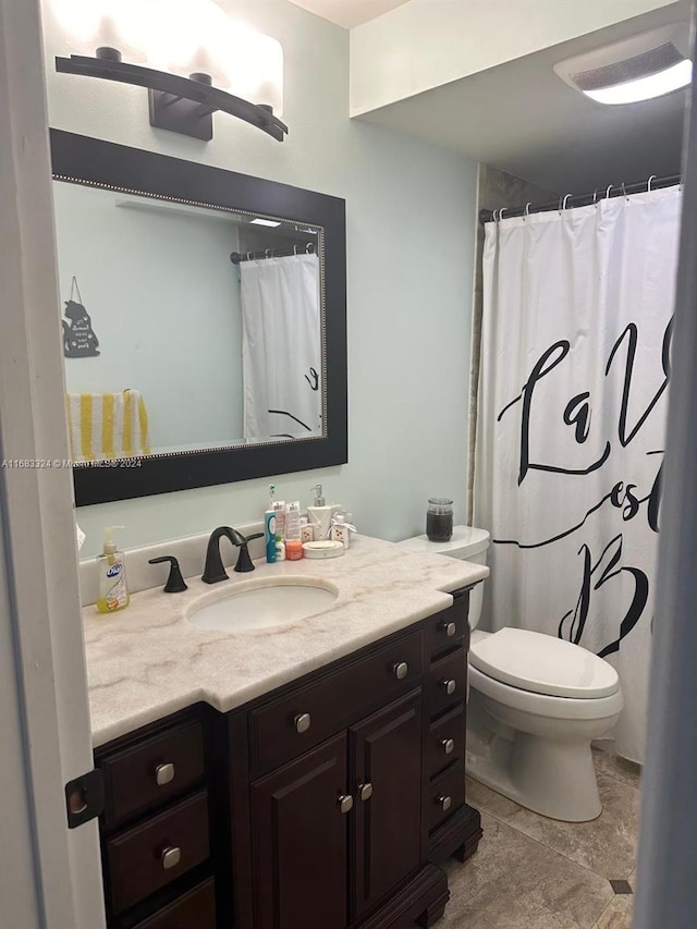 bathroom featuring vanity, curtained shower, toilet, and tile patterned floors