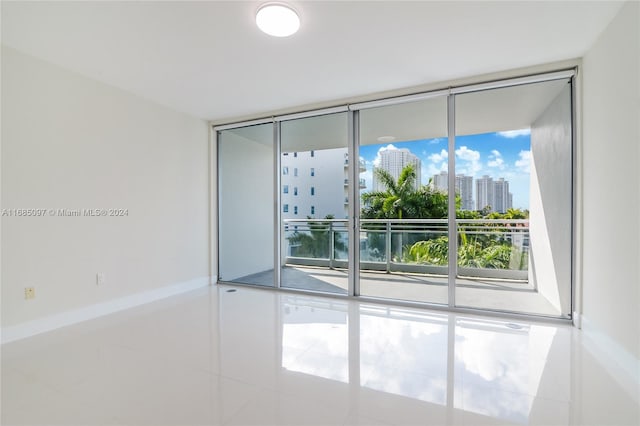 tiled empty room featuring expansive windows