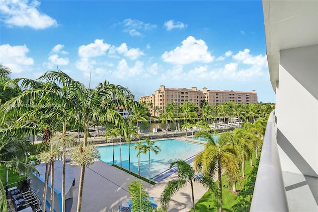 view of pool with a patio and a water view