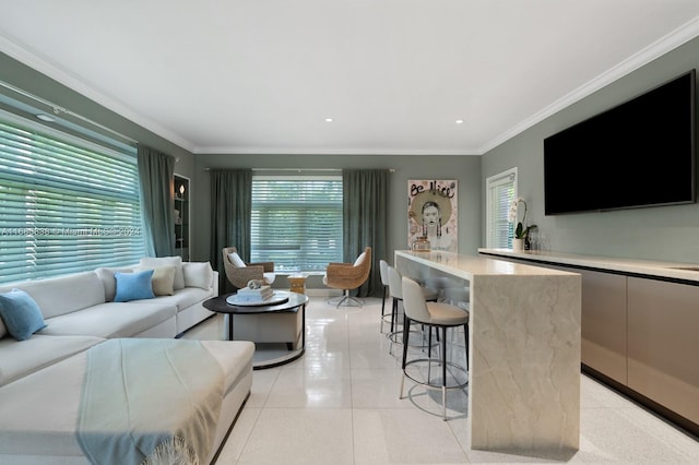 tiled living room with a wealth of natural light, ornamental molding, and bar area