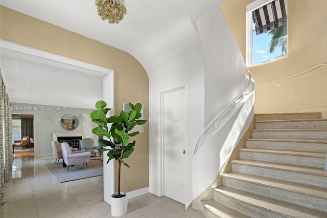 stairway featuring vaulted ceiling and tile patterned flooring