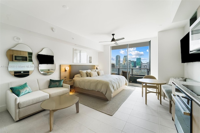 bedroom with expansive windows, access to exterior, and ceiling fan