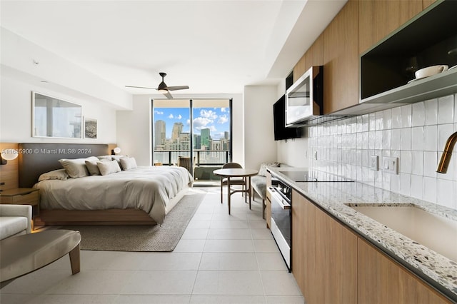 tiled bedroom with access to outside, sink, and ceiling fan