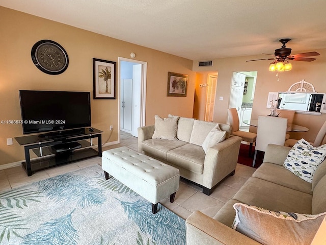 living room with ceiling fan and light tile patterned floors