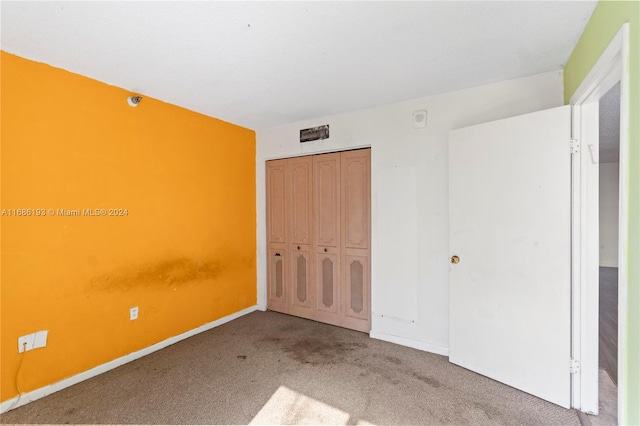 unfurnished bedroom featuring carpet flooring and a closet