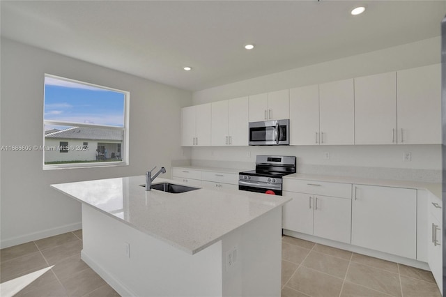 kitchen with appliances with stainless steel finishes, sink, an island with sink, and white cabinets