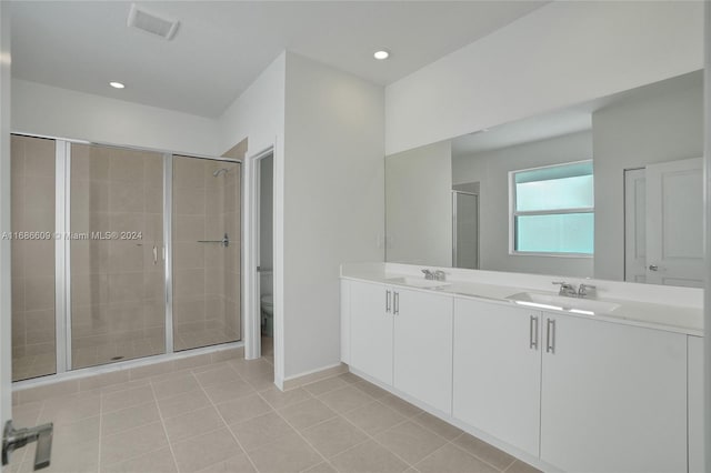 bathroom featuring walk in shower, tile patterned flooring, vanity, and toilet