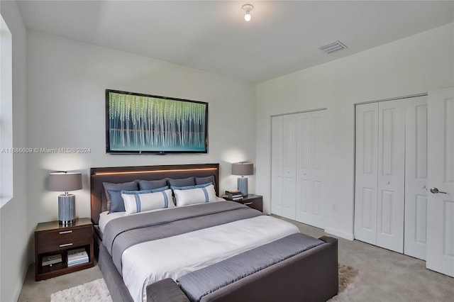 carpeted bedroom featuring two closets