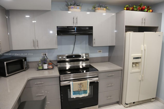 kitchen featuring exhaust hood, appliances with stainless steel finishes, gray cabinetry, and light tile patterned floors