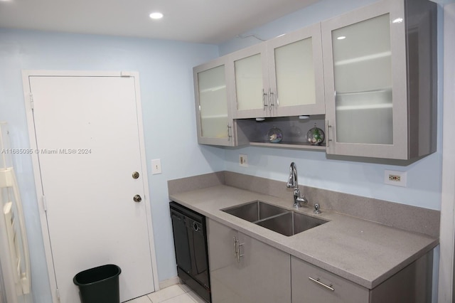 kitchen with sink, light tile patterned flooring, gray cabinetry, and dishwasher