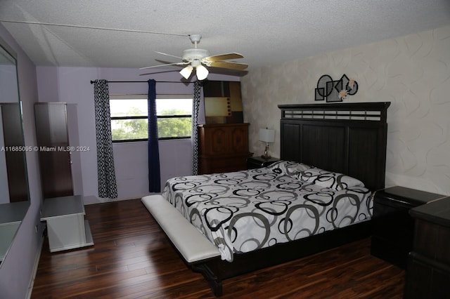 bedroom featuring a textured ceiling, dark hardwood / wood-style floors, and ceiling fan