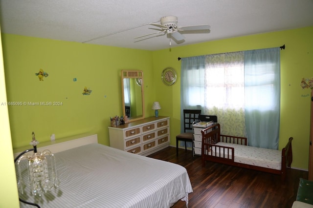 bedroom featuring dark wood-type flooring, ceiling fan, and a textured ceiling