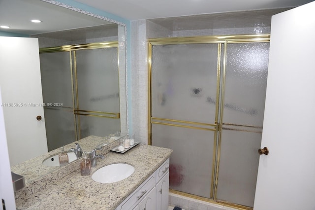 bathroom featuring vanity and a shower with door