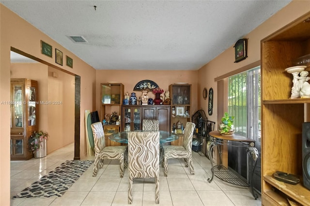 dining area with light tile patterned floors and a textured ceiling