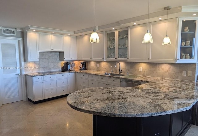 kitchen featuring white cabinetry and hanging light fixtures