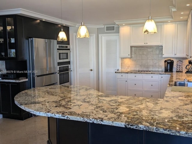 kitchen featuring stainless steel appliances, tasteful backsplash, crown molding, pendant lighting, and white cabinets