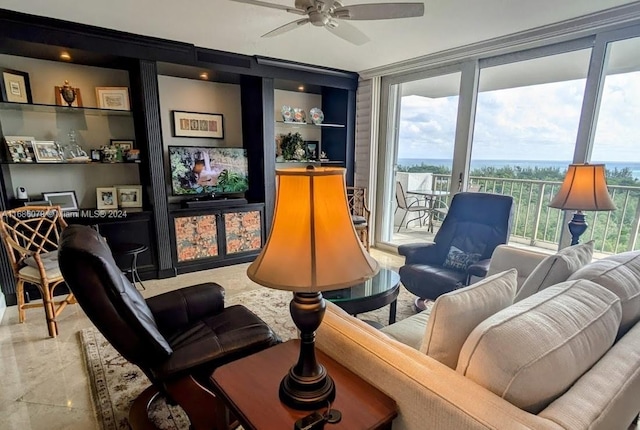 living area with built in shelves, a wealth of natural light, and ceiling fan