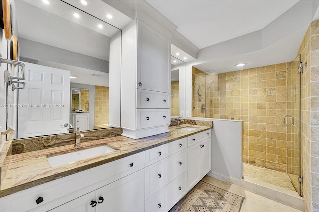 bathroom with tile patterned floors, vanity, and a tile shower